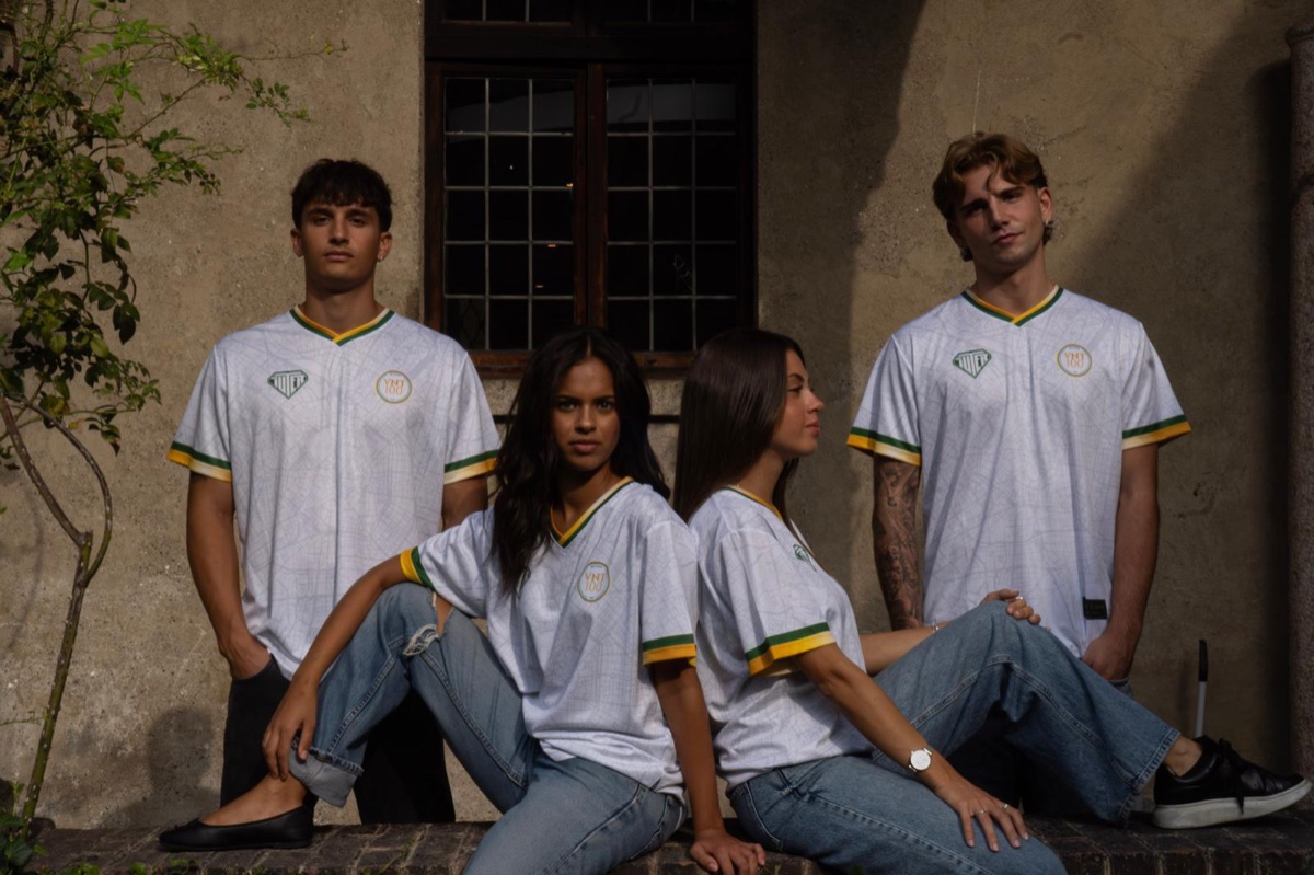 Quattro persone in posa con la HOME KIT VNT100 x IUTER: due ragazzi e due ragazze indossano la maglia bianca con la mappa di Milano
